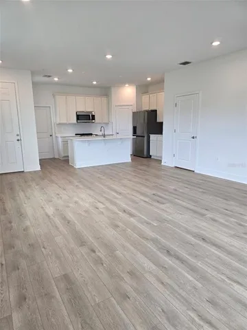 a view of kitchen with kitchen island and stainless steel appliances