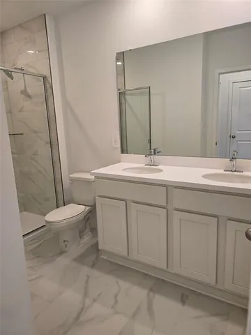 a bathroom with a sink toilet vanity and shower