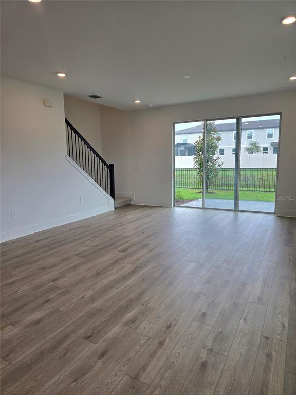 2445 Magnolia Reserve Road Ocoee, FL 34761 - Photo 10 of 19 a view of an empty room with wooden floor and a window