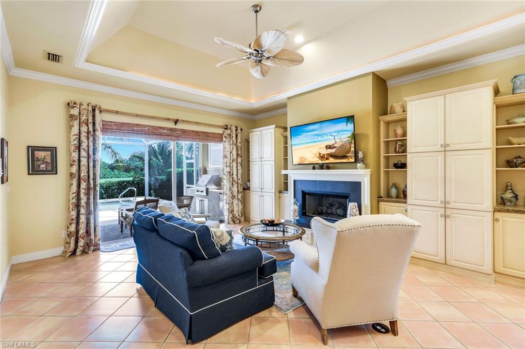 15588 Whitney Lane Naples, FL 34110 - Photo 13 of 47 a living room with furniture a fireplace and a large window