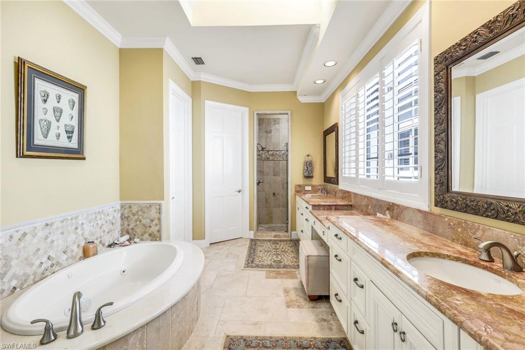 15588 Whitney Lane Naples, FL 34110 - Photo 17 of 47 a spacious bathroom with a tub sink and mirror