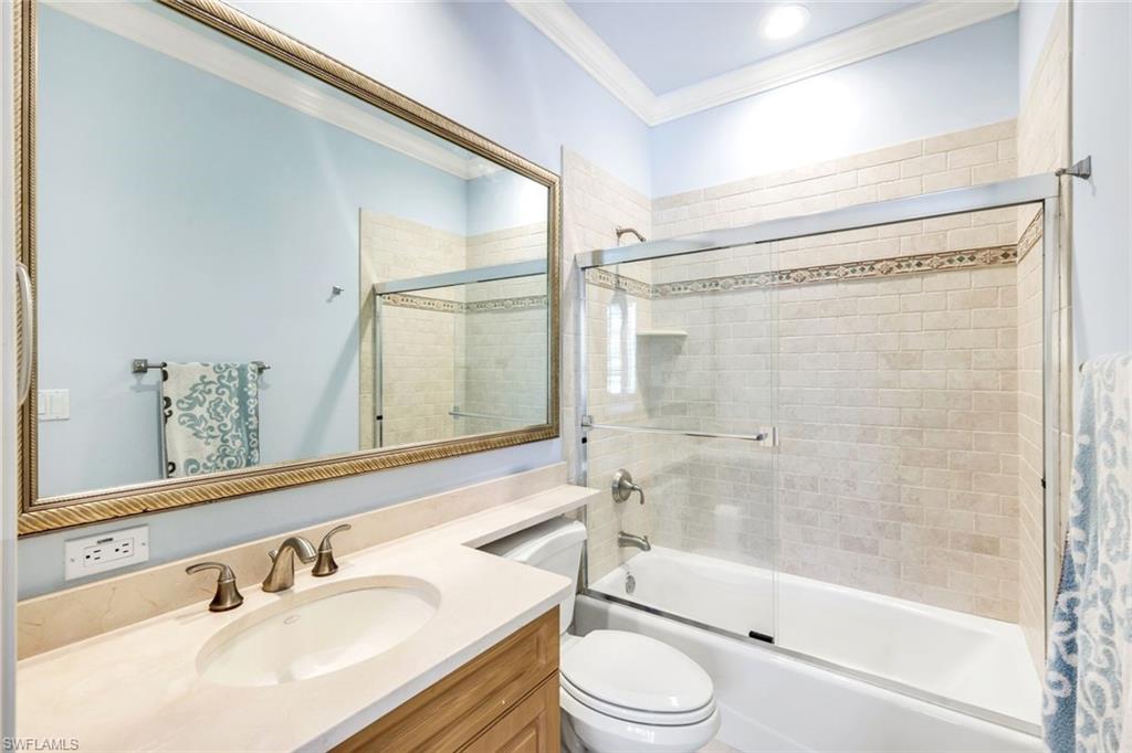 15588 Whitney Lane Naples, FL 34110 - Photo 20 of 47 a bathroom with a bathtub shower sink vanity mirror and toilet