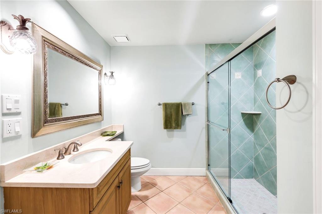 15588 Whitney Lane Naples, FL 34110 - Photo 25 of 47 a bathroom with a sink a toilet a mirror and shower