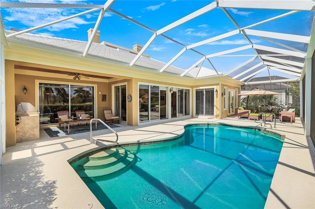 15588 Whitney Lane Naples, FL 34110 - Photo 26 of 47 a swimming pool with outdoor seating and a yard