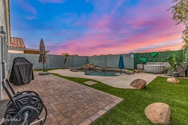 a view of a backyard with couches and swimming pool