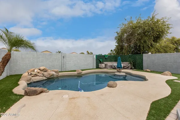 a view of a swimming pool with a yard and plants