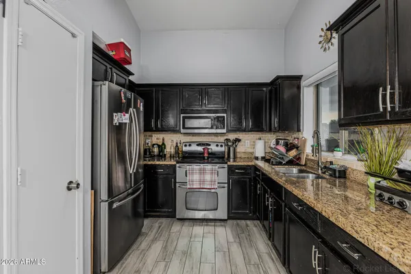 a kitchen with stainless steel appliances granite countertop a refrigerator stove microwave and sink