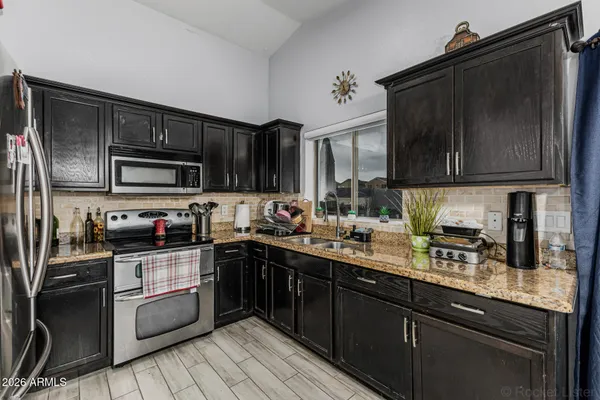 a kitchen with stainless steel appliances granite countertop a stove a sink dishwasher and a microwave oven on the granite countertops