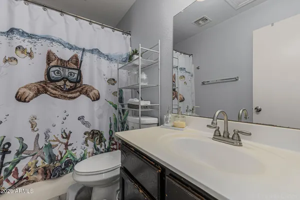 a bathroom with a sink a toilet and shower curtain