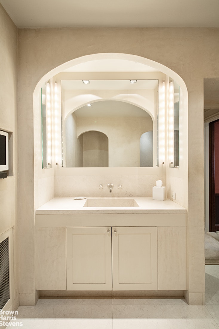 563 Park Avenue, Unit 5/6W Manhattan, NY 10065 - Photo 11 of 13 a bathroom with a sink a mirror and a vanity
