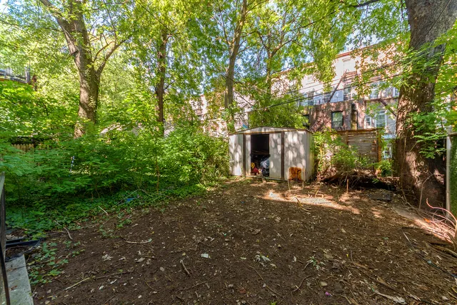a view of a house with backyard and trees