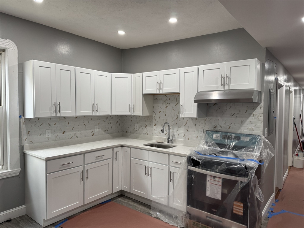 a kitchen with a sink stove and cabinets