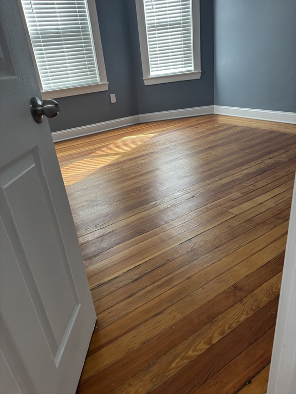 419 Seaver Street, Unit 3 Boston, MA 02121 - Photo 14 of 22 a view of an empty room with wooden floor and a window