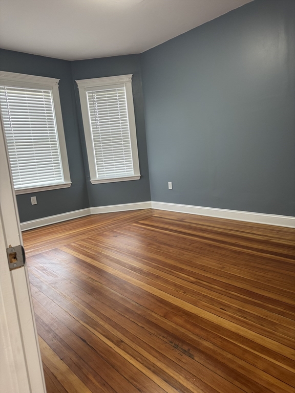 419 Seaver Street, Unit 3 Boston, MA 02121 - Photo 17 of 22 a view of an empty room with wooden floor and a window
