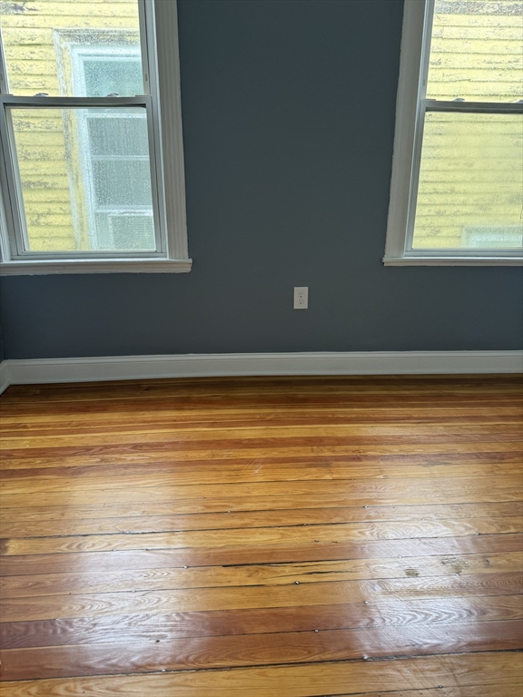 419 Seaver Street, Unit 3 Boston, MA 02121 - Photo 6 of 22 a view of an empty room with wooden floor and a window