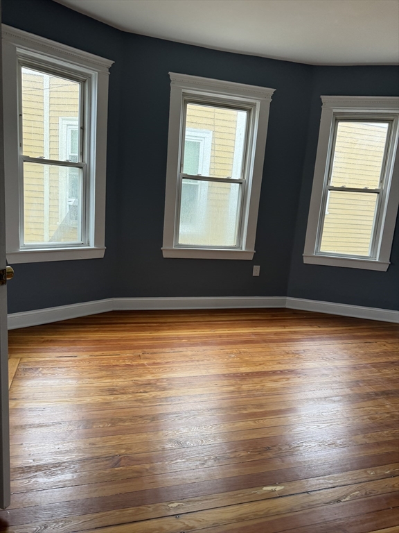 419 Seaver Street, Unit 3 Boston, MA 02121 - Photo 7 of 22 a view of an empty room with wooden floor and a window