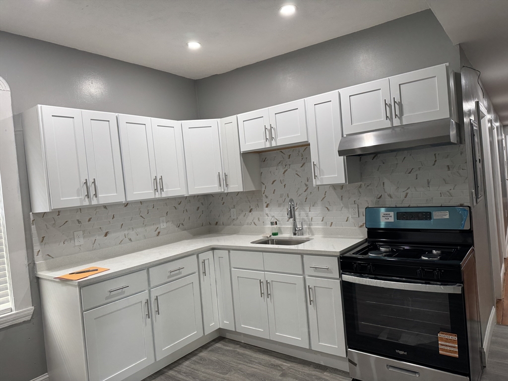 419 Seaver Street, Unit 3 Boston, MA 02121 - Photo 10 of 22 a kitchen with a sink stove and cabinets