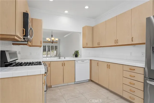 a kitchen with cabinets appliances a sink and a counter space