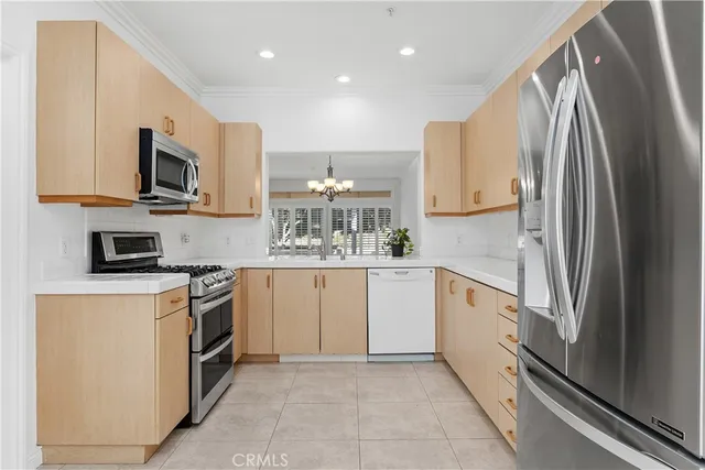 a kitchen with stainless steel appliances granite countertop a refrigerator sink and stove