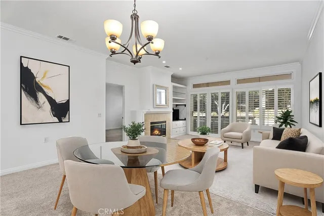 a living room with couches a dining table and a chandelier