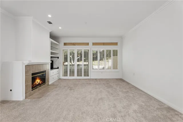 a view of an empty room with a fireplace and a window