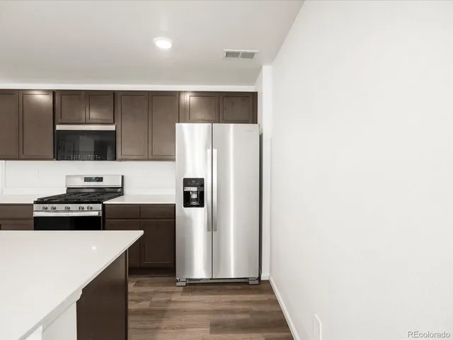 a kitchen with a refrigerator and a stove