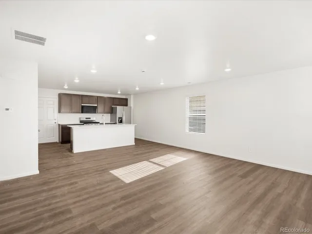 a view of kitchen with wooden floor and electronic appliances