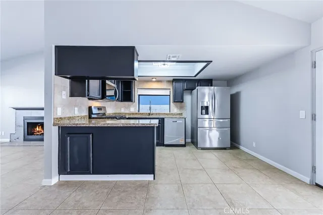 a view of a kitchen with refrigerator and cabinets