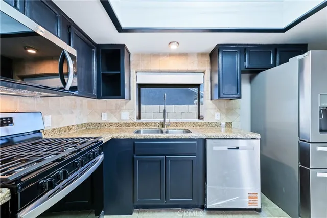 an empty room with wooden floor cabinet and windows
