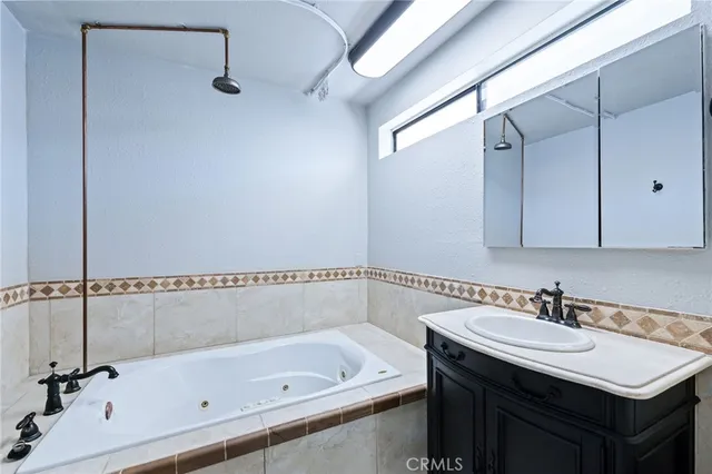 an empty room with wooden floor ceiling fan and windows