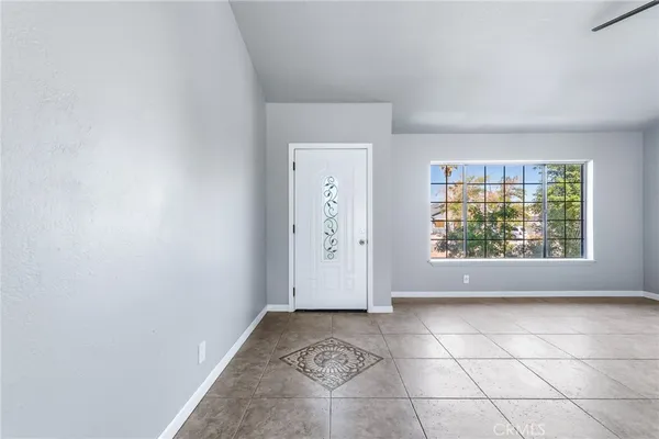 a view of an empty room with a window and a fireplace