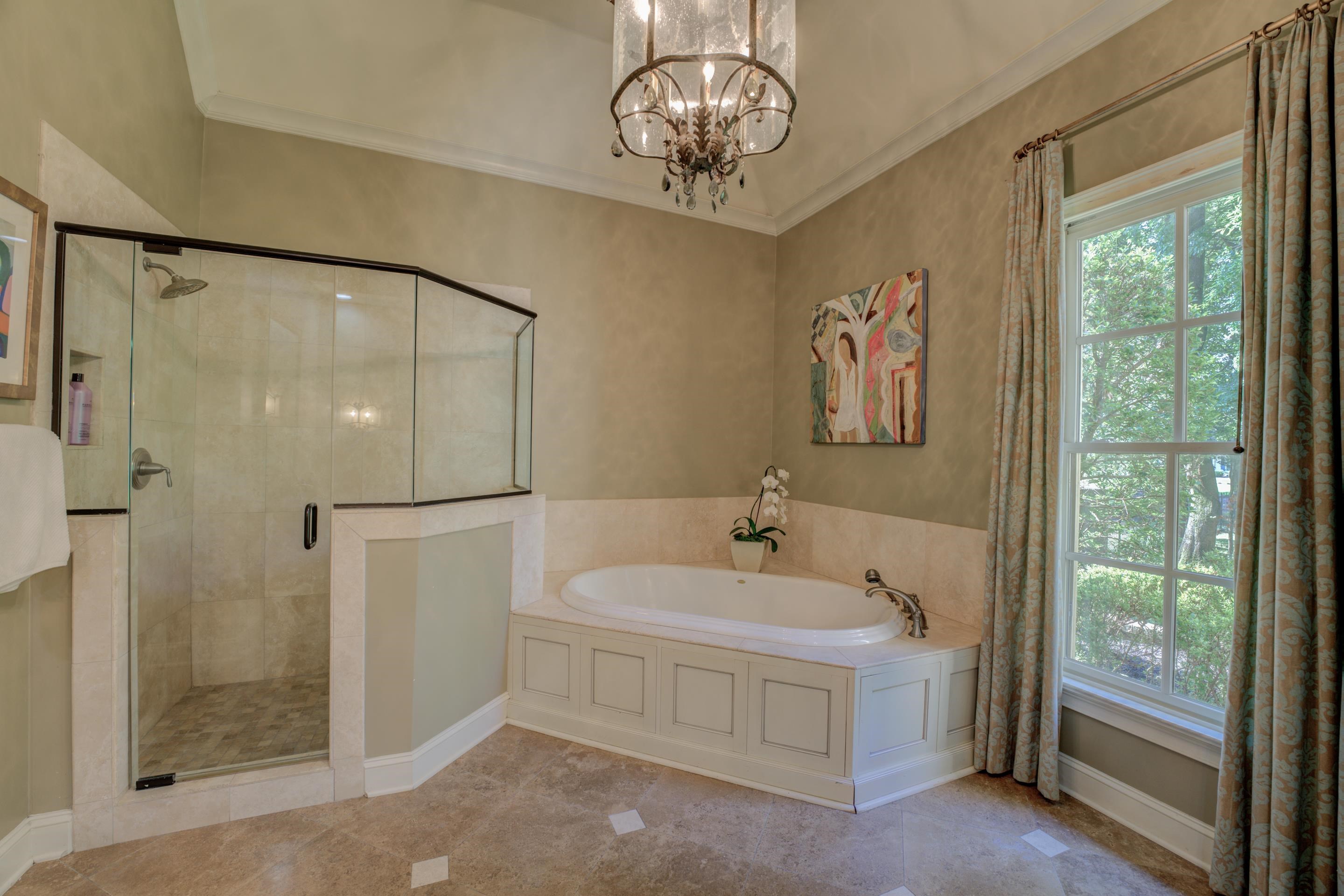 5074 Shady Grove Road Memphis, TN 38117 - Photo 12 of 25 Immerse yourself in the tranquility of a spa-like retreat, complete with a luxurious tub, a separate walk-in shower, and dual vanity sinks adorned with exquisite finishes.