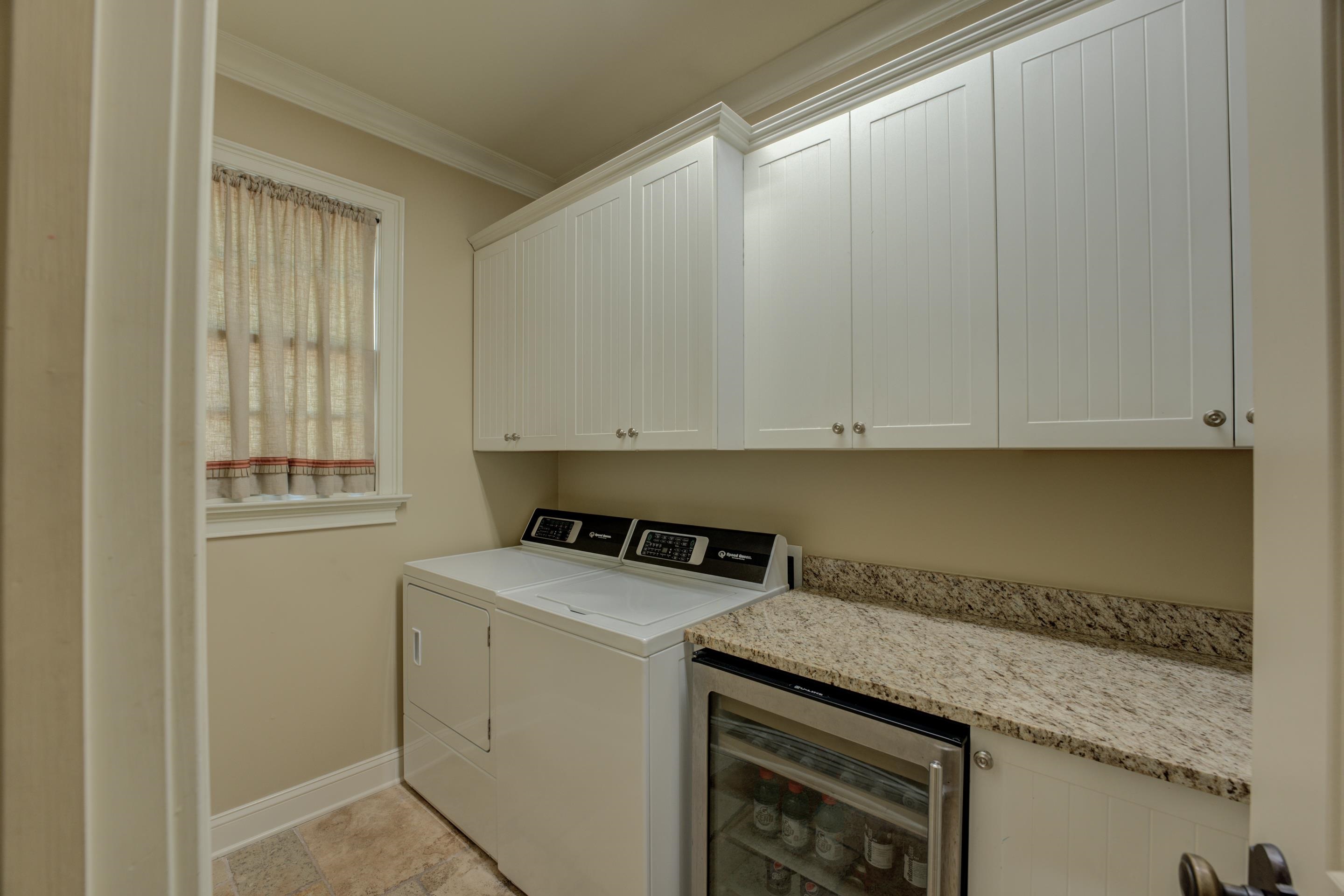 5074 Shady Grove Road Memphis, TN 38117 - Photo 20 of 25 The laundry room, complete with cabinets and a wine refrigerator, adds convenience and functionality.