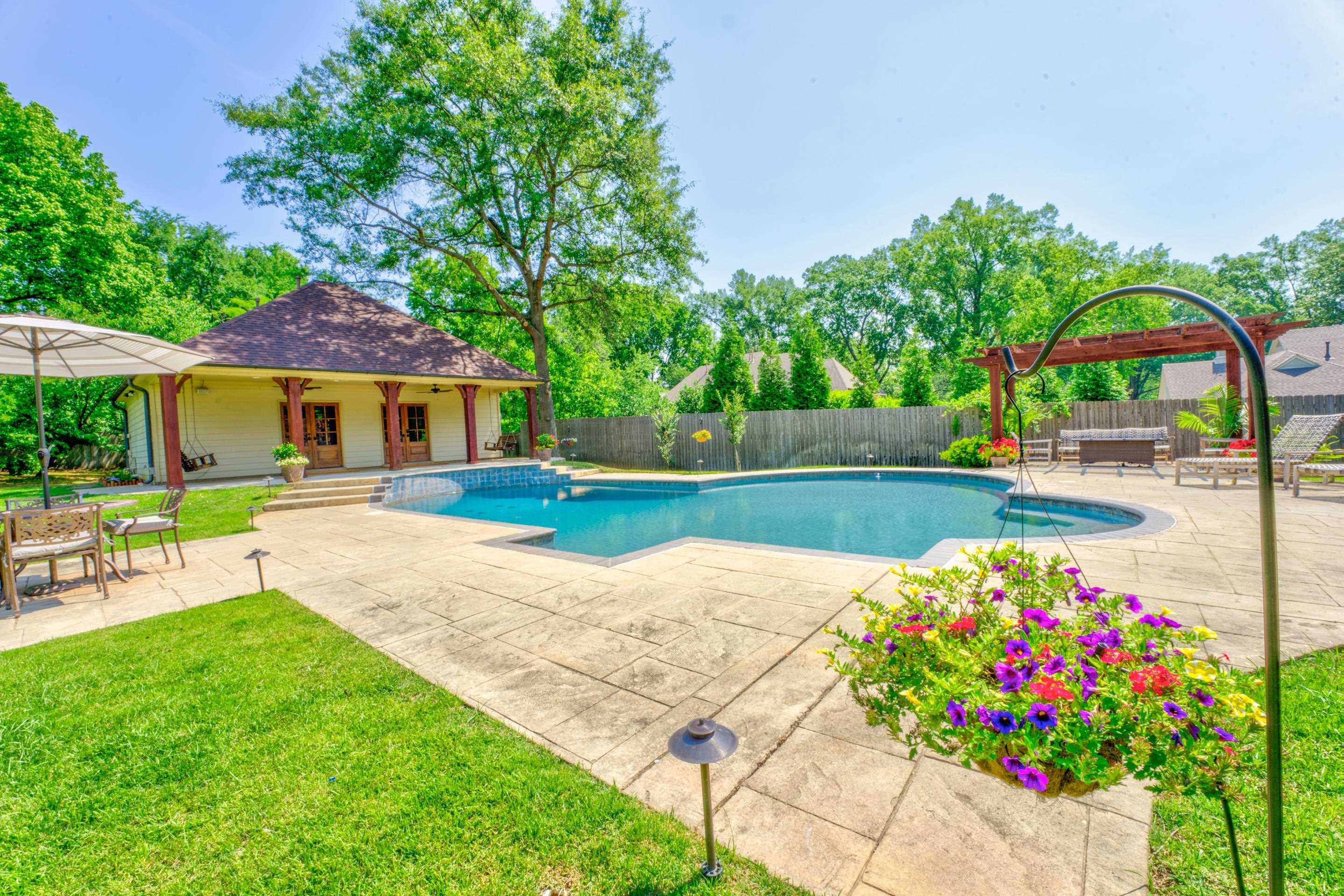 The backyard is a haven for relaxation and entertainment, boasting an in-ground gunite pool and a charming arbor, where you can bask in the warm sunshine or host memorable gatherings with friends and family.