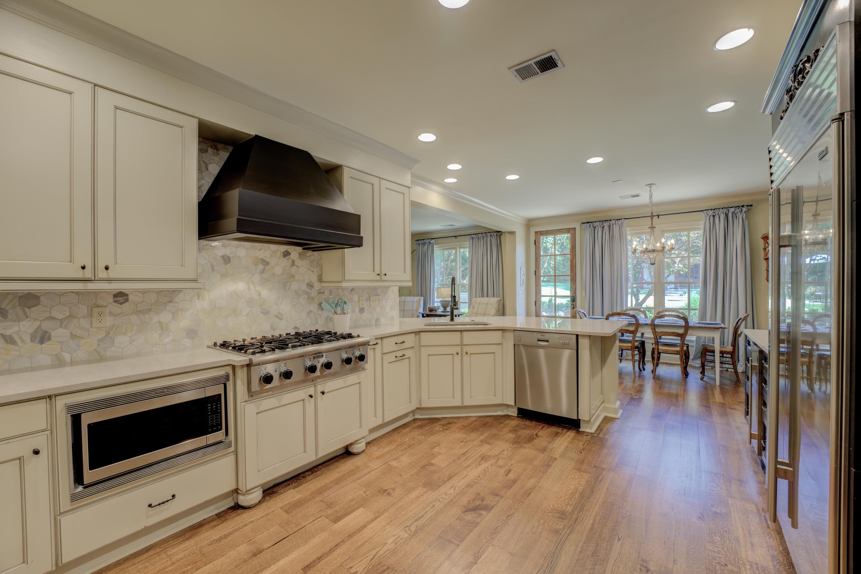 The updated kitchen is a chef's dream, equipped with granite countertops, stainless steel appliances including a double oven, Subzero refrigerator, and gas cook-top, a separate ice maker, a warming drawer, and a convenient breakfast bar.