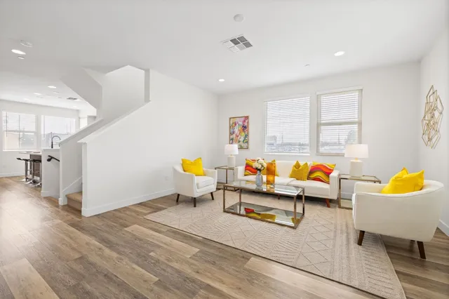 a living room with furniture and wooden floor