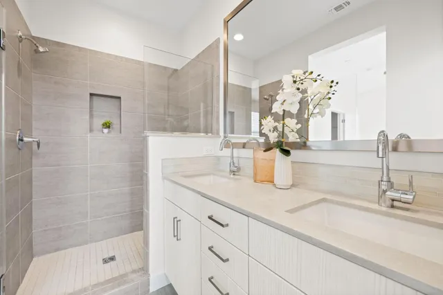 a bathroom with a sink a mirror and a shower