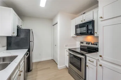 a kitchen with stainless steel appliances a stove microwave and sink