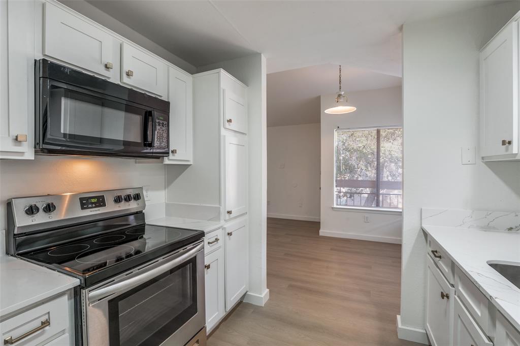 5550 Spring Valley Road, Unit D31 Dallas, TX 75254 - Photo 8 of 19 a kitchen with a stove microwave and cabinets