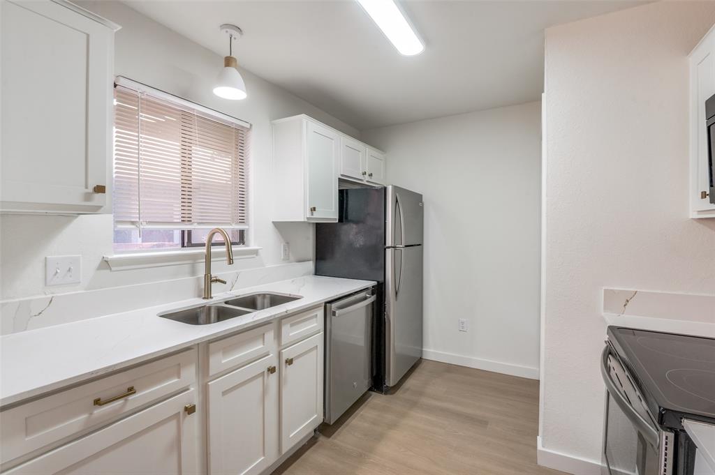 5550 Spring Valley Road, Unit D31 Dallas, TX 75254 - Photo 10 of 19 a kitchen with stainless steel appliances granite countertop a sink and a refrigerator