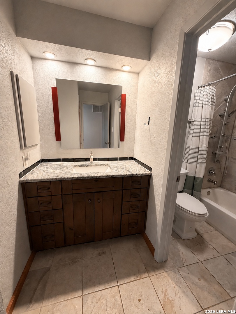 14343 Judson Road, Unit 302 San Antonio, TX 78233 - Photo 5 of 14 a bathroom with a granite countertop sink and a mirror