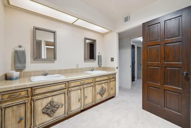 a spacious bathroom with a double vanity sink and a mirror