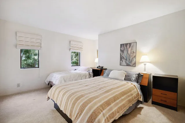 a bedroom with two beds and a night stand