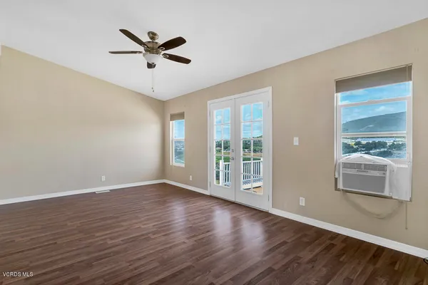 a view of a livingroom with wooden floor and a ceiling fan