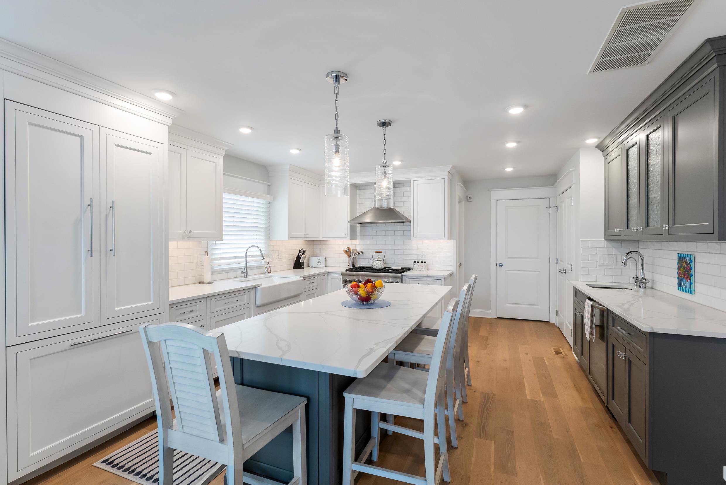 253 35th, Unit WEST Avalon, NJ 08202 - Photo 21 of 43 a kitchen with stainless steel appliances a dining table chairs stove refrigerator and cabinets