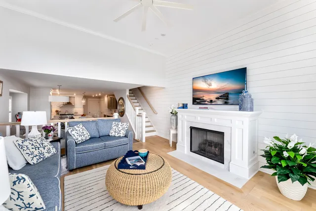 a living room with furniture a flat screen tv and a fireplace