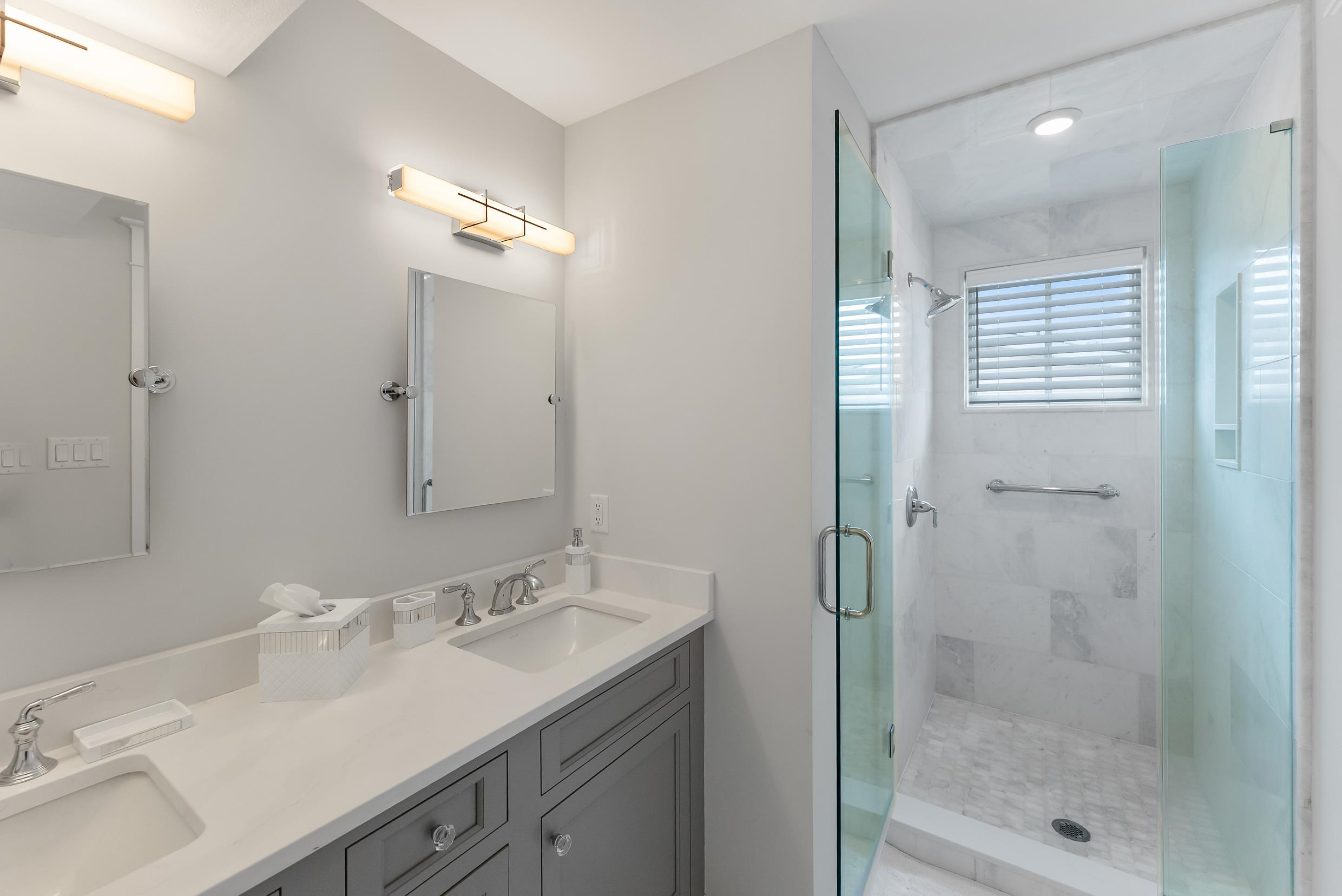 253 35th, Unit WEST Avalon, NJ 08202 - Photo 38 of 43 a bathroom with a shower sink vanity and mirror