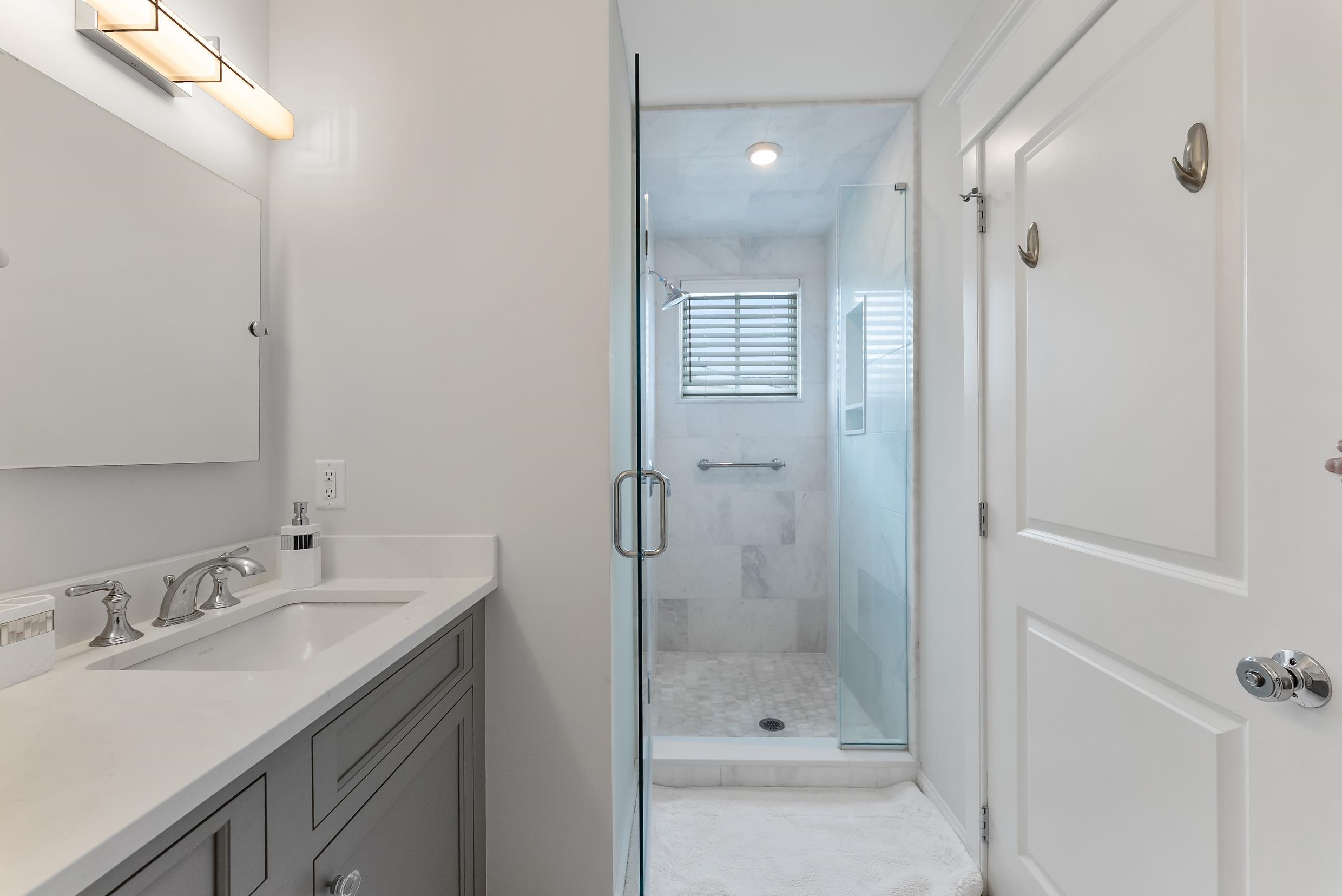 253 35th, Unit WEST Avalon, NJ 08202 - Photo 39 of 43 a bathroom with a shower sink vanity and mirror