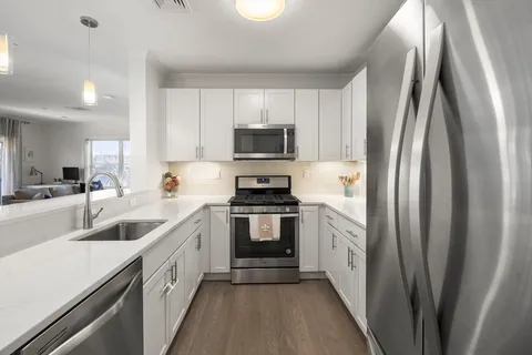 a kitchen with white cabinets and stainless steel appliances