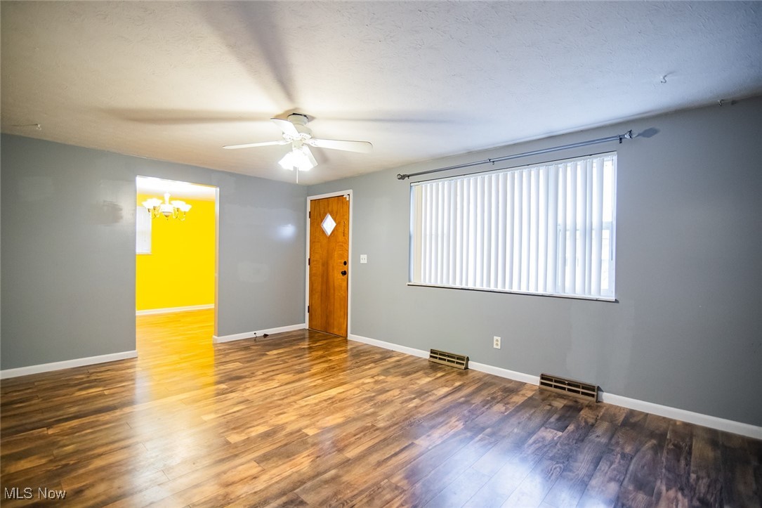 91 Mike Street Washington, WV 26181 - Photo 16 of 42 Unfurnished living room with a ceiling fan, dark wood-style flooring, a chandelier, and a textured ceiling